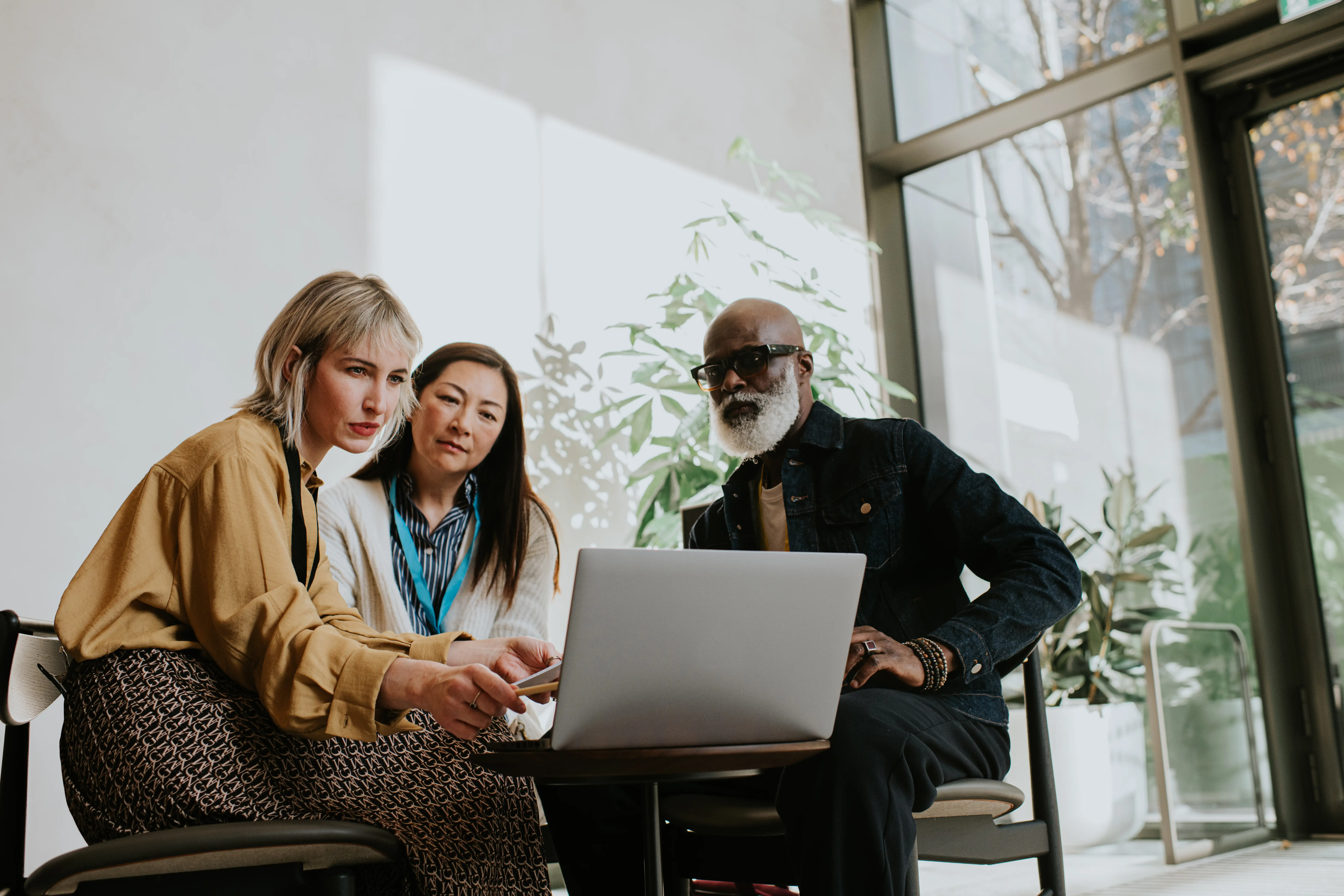 three people looking at a laptop