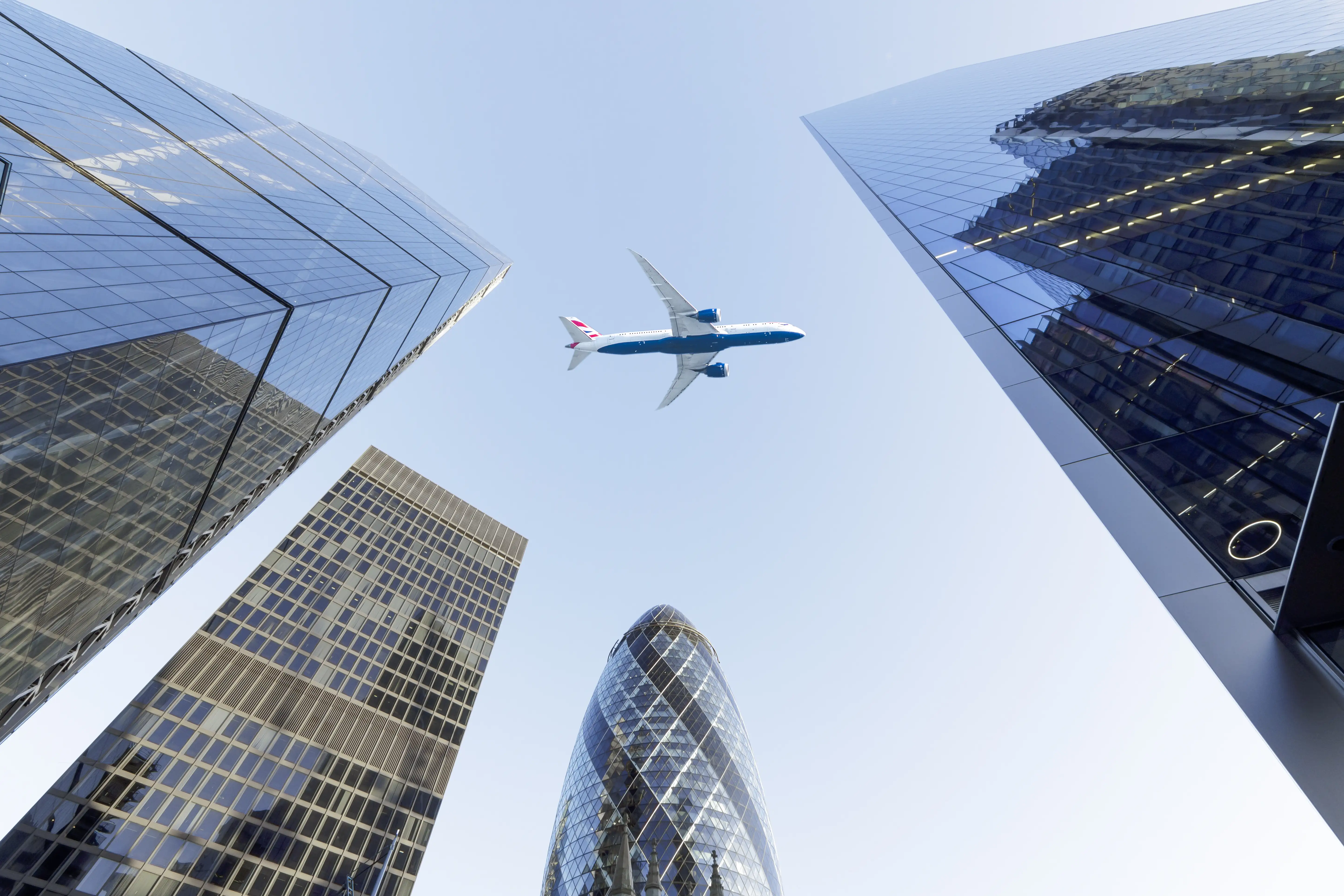 plane flying over skyscrapers